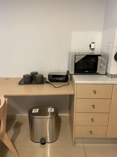 a kitchen with a table with a microwave on it at Υπέροχο διαμέρισμα με πάρκινγκ in Larisa