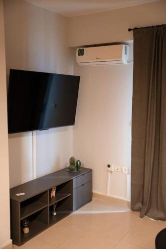 a living room with a flat screen tv on the wall at Υπέροχο διαμέρισμα με πάρκινγκ in Larisa