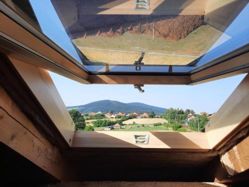 a view from a window in a house with a cross on it at Kosmaj IKIGAI in Nemenikuće