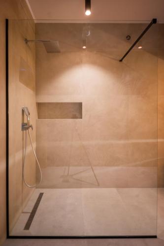 a shower with a glass door in a bathroom at Kosmaj IKIGAI in Nemenikuće