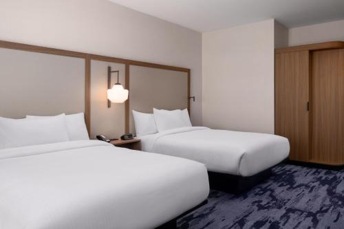 two beds in a hotel room with white sheets at Fairfield by Marriott Inn & Suites Waycross in Waycross