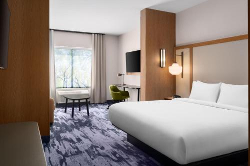 a hotel room with a large white bed and a desk at Fairfield by Marriott Inn & Suites Waycross in Waycross