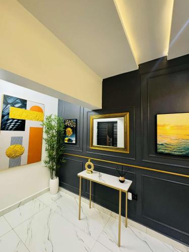 Habitación con mesa y pinturas en la pared. en Tastic Homes ng, en Port Harcourt