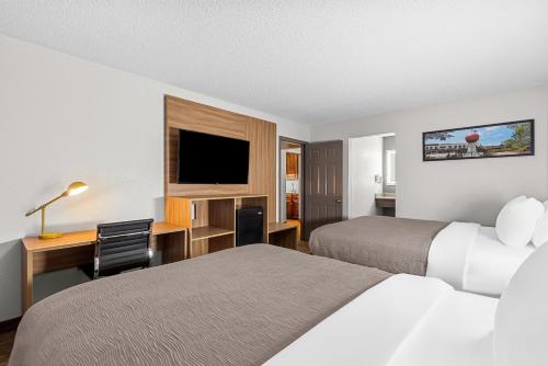 a hotel room with two beds and a desk at Quality Inn in Cornelia