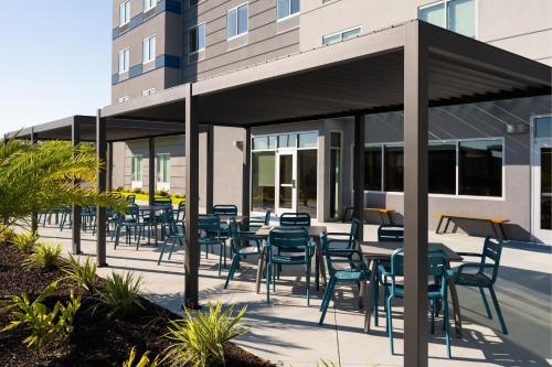 a patio with tables and chairs in front of a building at Fairfield by Marriott Inn & Suites Waycross in Waycross