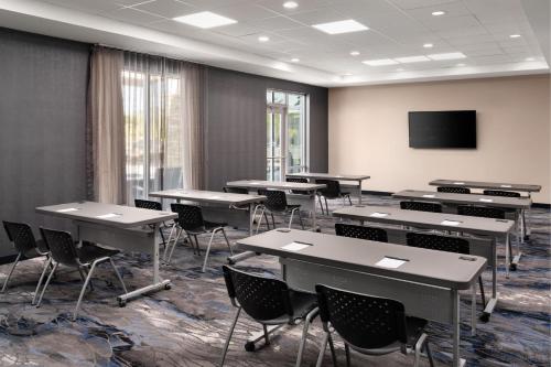 a classroom with tables and chairs and a flat screen tv at Fairfield by Marriott Inn & Suites Waycross in Waycross