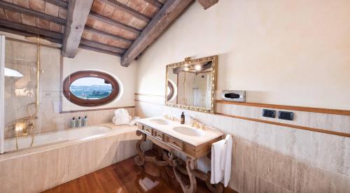 bagno con lavandino, vasca e specchio di Hotel Casa Pavesi a Grinzane Cavour