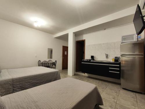 a hotel room with two beds and a sink at Villa Bilac - Amplos Studios 2km da Vila Germânica in Blumenau