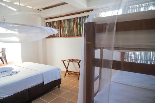 a bedroom with a bed and a bunk bed at Hostal Casa en la Ciénaga Rincon del Mar in Rincón