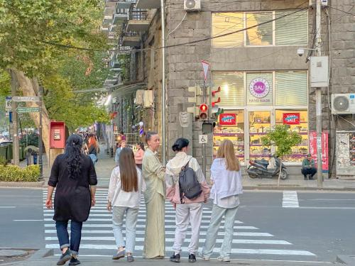 un gruppo di persone che attraversa la strada sulle strisce pedonali di Современная студия в центре a Yerevan