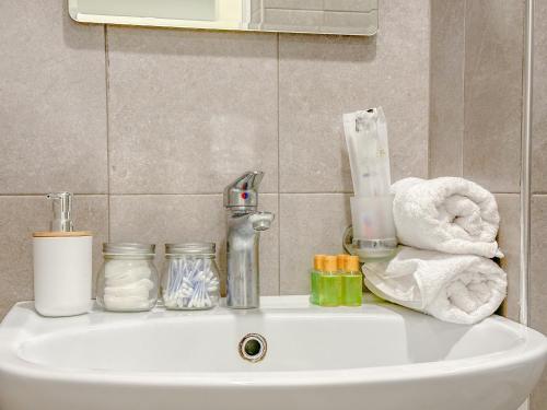 ein Waschbecken im Badezimmer mit Handtüchern und einem Wasserhahn in der Unterkunft Современная студия в центре in Yerevan