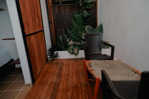 a room with a table and a chair and some plants at Hostal Casa en la Ciénaga Rincon del Mar in Rincón
