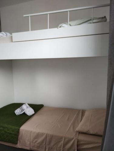 a room with a bed with a shelf and shoes on it at Recanto da Sol in Florianópolis