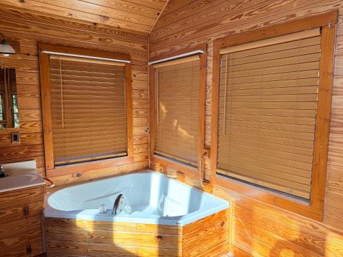 a large bath tub in a wooden room with windows at great escape in Sevierville