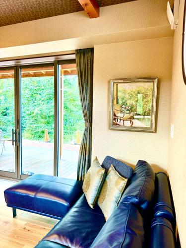 a blue leather couch in a living room with a window at Private Villa ietona in Fujikawaguchiko