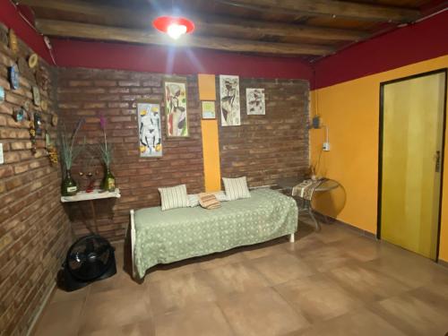 ein Schlafzimmer mit einem Bett und einer Ziegelwand in der Unterkunft CASA RINCON DE VISTALBA in Vistalba