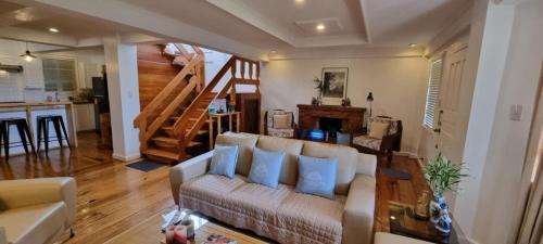 a living room with a couch and a staircase at Whyte Pyne Transient House in Baguio
