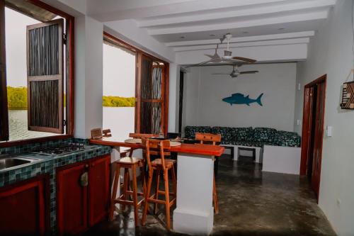 a kitchen with a counter and a table with chairs at Hostal Casa en la Ciénaga Rincon del Mar in Rincón