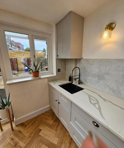 a kitchen with a sink and a window at Wembley London lovely 6 bed House sleeps up to 14 in London