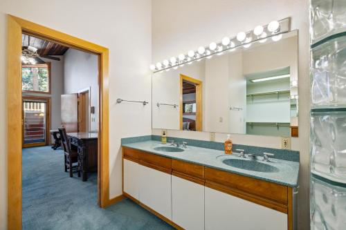 a bathroom with two sinks and a large mirror at New! Birch Fairway House - On golf course - Hot tub - Garage - Family friendly in McCall