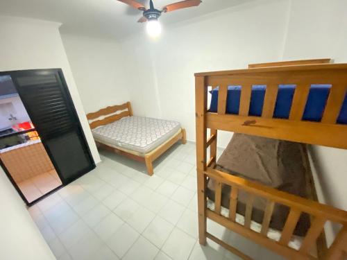 a room with a bunk bed and a chair at Pé na areia praia da Guilhermina III in Praia Grande
