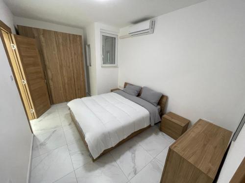 a bedroom with a bed and a wooden cabinet at Lovely room near Balluta Bay RB in San Ġwann