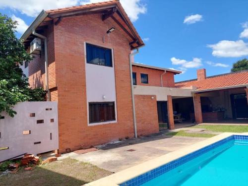 a brick house with a swimming pool in front of it at Residencia Las Marías in Pilar