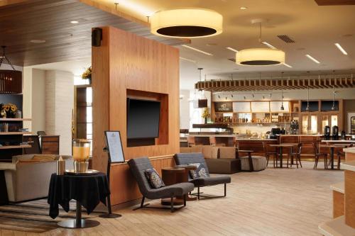 a lobby with a waiting area with chairs and tables at Courtyard by Marriott Erie Bayfront in Erie