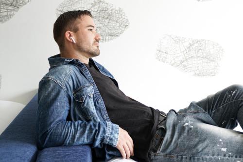 a man sitting on a couch wearing a denim jacket at Aloft Osaka Dojima in Osaka