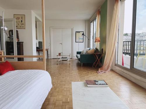 une chambre avec un lit et un salon dans l'établissement Vaste appt baigné de lumière, à Paris