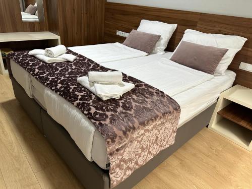 a bedroom with a large bed with towels on it at Green Elite Residence in Sarajevo