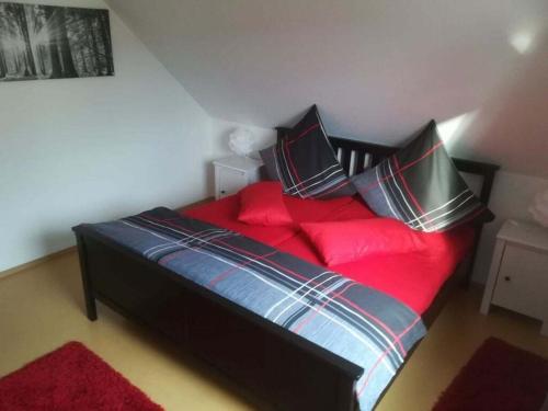 a bedroom with a bed with red sheets and pillows at Tromm - Blick Comfortable holiday residence in Rimbach