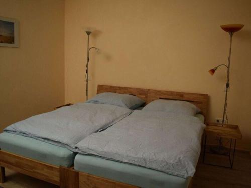 a bed in a bedroom with two lamps on two tables at Köhler - Hütte Comfortable holiday residence in Brilon