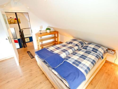 a bedroom with a bed with blue and white sheets at LebensArt in the old horse stable in Erndtebrück