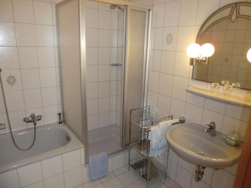 a bathroom with a shower and a sink and a tub at Marmann - large holiday apartment in Osann-Monzel