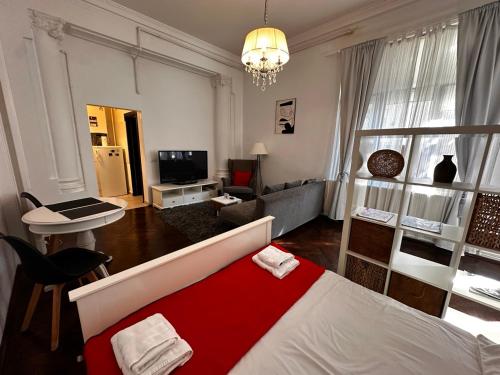a living room with a bed with a red blanket at Cismigiu Apartments in Bucharest
