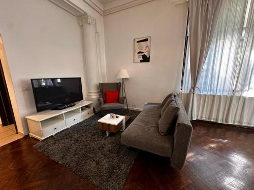 a living room with a couch and a flat screen tv at Cismigiu Apartments in Bucharest