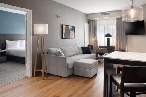 a living room with a couch and a room with a bed at Residence Inn by Marriott Fort Smith in Massard