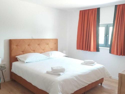a bedroom with a large bed with two towels on it at Bagulina Comfortable holiday residence in Drniš