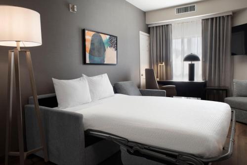 a hotel room with a bed and a chair at Residence Inn by Marriott Fort Smith in Massard