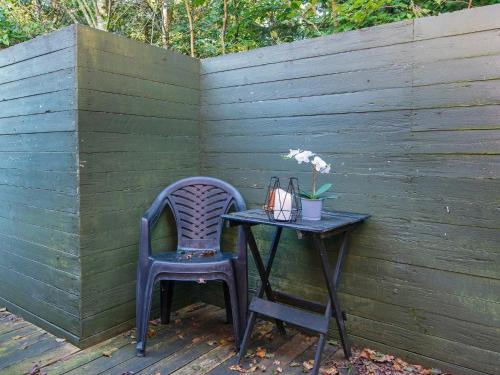 a table and chair next to a wooden fence with a table and a table at Modern Retreat in Arrild - By Traum Ferienwohnungen in Toftlund