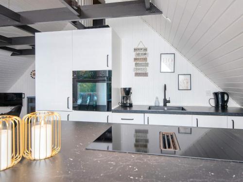 a kitchen with white cabinets and a black counter top at Modern Retreat in Arrild - By Traum Ferienwohnungen in Toftlund