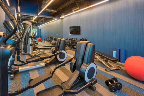a gym with a lot of treadmills and weights at Aloft Portland Airport Hotel at Cascade Station in Portland