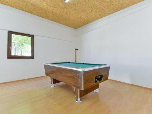 a pool table in a white room with a table at Marinic Comfortable holiday residence in Zadar