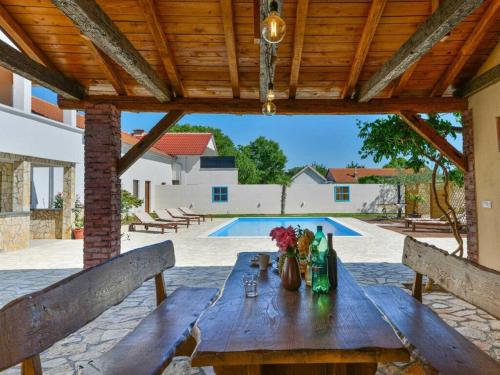 a wooden table with flowers on top of a patio at Marinic Comfortable holiday residence in Zadar