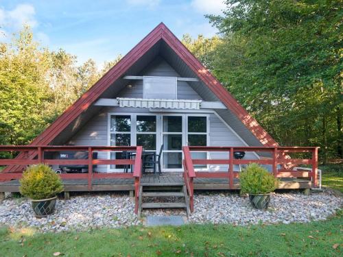 a tiny house with a porch and two red chairs at Modern Retreat in Arrild - By Traum Ferienwohnungen in Toftlund