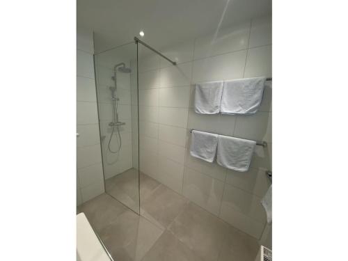 y baño con cabina de ducha de cristal y toallas. en Apartment Annemarie 3, en Meersburg