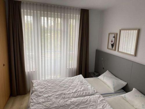 a bedroom with a bed and a large window at 101 in the Vitamar holiday park in Dorum