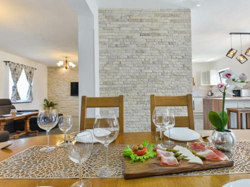 a dining table with wine glasses and food on it at Marinic Comfortable holiday residence in Zadar