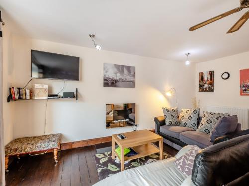a living room with a couch and a tv at The Drovers Rest - Uk43567 in Haltwhistle